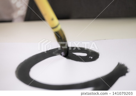 特寫鏡頭拍攝了一名沒有面孔的小學生學習書法時,專注地用毛筆寫字的雙手。 特寫鏡頭拍攝了一名沒有面孔的小學生學習書法時,專注地用毛筆寫字的雙手。 141070203