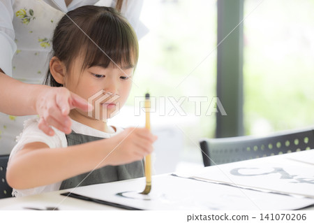 一位小學生正專心致志地練習書法,用毛筆書寫文字;笑容燦爛的日本兒童正在學習書法。 一位小學生正專心致志地練習書法,用毛筆書寫文字;笑容燦爛的日本兒童正在學習書法。 141070206