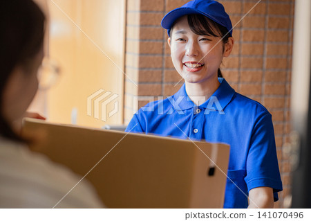 A courier female driver delivering a package A courier female driver delivering a package 141070496