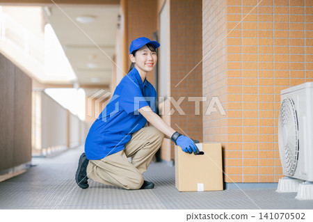 工作人員將包裹放在門口 141070502