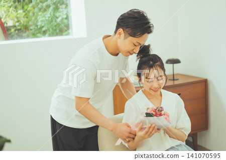 一對面帶著平靜表情的情侶一起欣賞一束鮮花。 一對面帶著平靜表情的情侶一起欣賞一束鮮花。 141070595