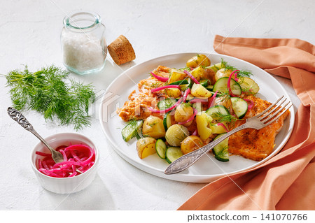 Baked salmon fillet, new potatoes, pickled onion 141070766