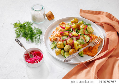 Baked salmon fillet, new potatoes, pickled onion 141070767
