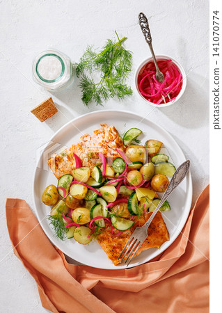Baked salmon fillet, new potatoes, pickled onion 141070774