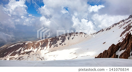 Mountains show snow with clouds and blue sky during daytime in a scenic landscape view Mountains show snow with clouds and blue sky during daytime in a scenic landscape view 141070834
