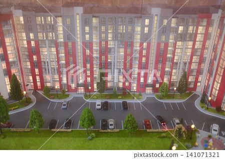Model of a building, trees, parking spaces, and cars are displayed Model of a building, trees, parking spaces, and cars are displayed 141071321