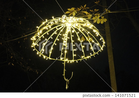 Umbrella shaped light decoration shines brightly outdoors at night Umbrella shaped light decoration shines brightly outdoors at night 141071521