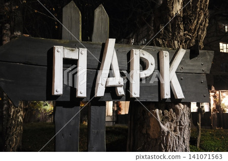 Rustic black wooden sign directs toward a park. Rustic black wooden sign directs toward a park. 141071563