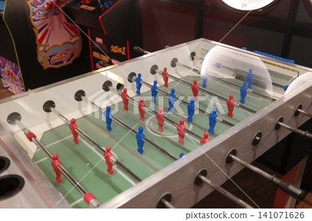 Red and blue foosball player figures stand on a green field Red and blue foosball player figures stand on a green field 141071626