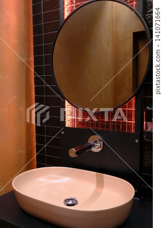 Modern bath: peach oval sink, black tiles, sleek faucet, warm glow mirror Modern bath: peach oval sink, black tiles, sleek faucet, warm glow mirror 141071664