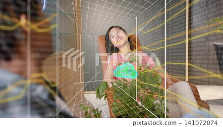 Smiling woman wearing pink top reclining in armchair at office lounge, showing cloud hologram Smiling woman wearing pink top reclining in armchair at office lounge, showing cloud hologram 141072074