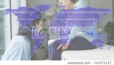 Kneeling blue-shirt woman checking green-shirt man on sofa touching knee at home, with map overlay Kneeling blue-shirt woman checking green-shirt man on sofa touching knee at home, with map overlay 141072127