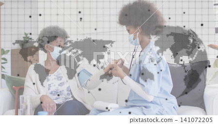 Checking nurse in scrubs leaning toward senior patient on sofa, taking blood pressure with cuff Checking nurse in scrubs leaning toward senior patient on sofa, taking blood pressure with cuff 141072205