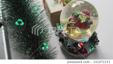 Glowing glass snow globe showing red suit Santa, child-figure on table with teal glints, copy space Glowing glass snow globe showing red suit Santa, child-figure on table with teal glints, copy space 141072231