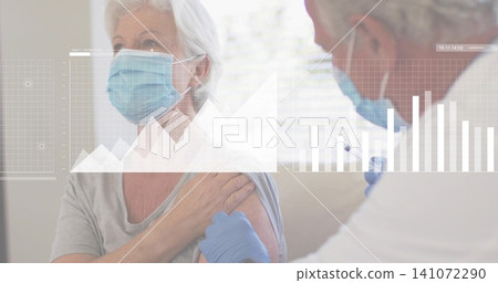 Giving doctor injecting masked senior woman in grey top at clinic, with syringe blue gloves graphs Giving doctor injecting masked senior woman in grey top at clinic, with syringe blue gloves graphs 141072290
