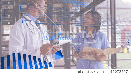 Reviewing staff wearing lab coat and scrubs checking records in clinic hall with tablet and charts Reviewing staff wearing lab coat and scrubs checking records in clinic hall with tablet and charts 141072297