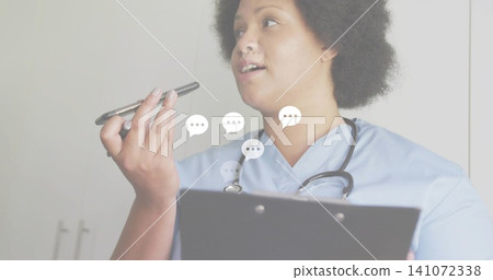 Speaking nurse in blue scrubs holding phone to mouth and clipboard in clinic, wearing stethoscope Speaking nurse in blue scrubs holding phone to mouth and clipboard in clinic, wearing stethoscope 141072338