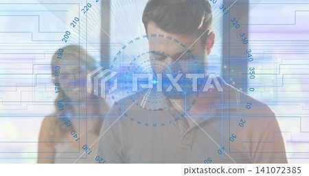 Standing man in polo studying blue HUD in office, partner in sleeveless top and glasses observing Standing man in polo studying blue HUD in office, partner in sleeveless top and glasses observing 141072385