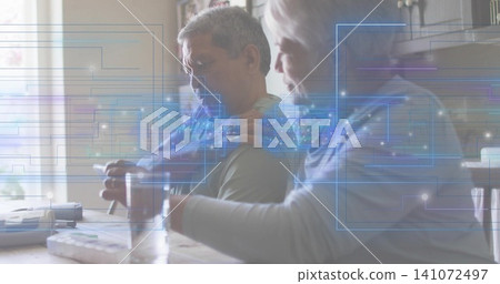 Sitting seniors managing pill box, monitor on kitchen table, wearing muted shirt, light sweater Sitting seniors managing pill box, monitor on kitchen table, wearing muted shirt, light sweater 141072497