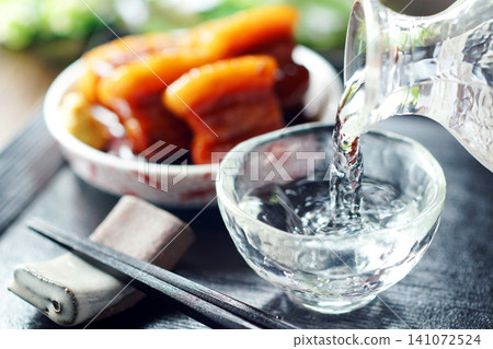 Sake is poured and braised pork belly is served. Sake is poured and braised pork belly is served. 141072524