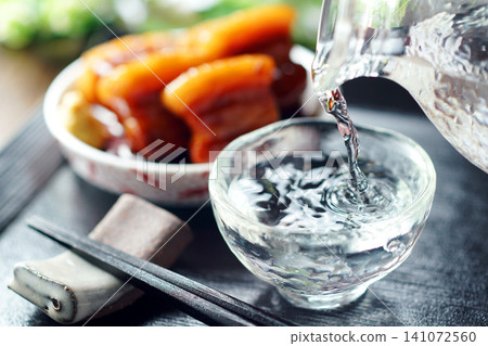 Sake is poured and braised pork belly is served. Sake is poured and braised pork belly is served. 141072560