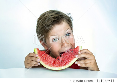 Boy Eating Watermelon Slice with Joy and Playful Expression Boy Eating Watermelon Slice with Joy and Playful Expression 141072611