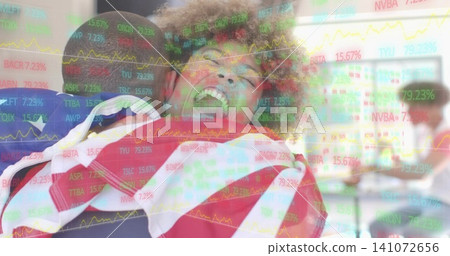 Laughing woman wrapped in American flag being lifted by friends in classroom, with market overlay Laughing woman wrapped in American flag being lifted by friends in classroom, with market overlay 141072656