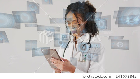 Holding tablet, physician reviewing digital panels at clinic, wearing lab coat and stethoscope Holding tablet, physician reviewing digital panels at clinic, wearing lab coat and stethoscope 141072842
