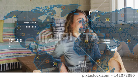 Leaning back adult woman wearing light-gray top and tan shorts at home, viewing AR map overlay Leaning back adult woman wearing light-gray top and tan shorts at home, viewing AR map overlay 141072890