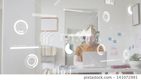 Working male worker wearing mustard shirt interacting with laptop at home, HUD overlays present Working male worker wearing mustard shirt interacting with laptop at home, HUD overlays present 141072991
