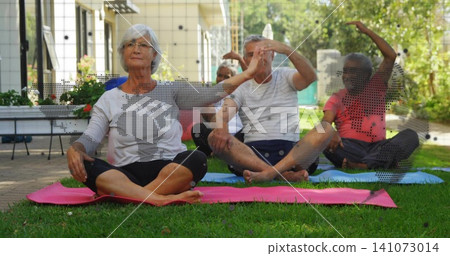 Stretching senior adults doing seated side bends on garden lawn in workoutwear, with yoga mats Stretching senior adults doing seated side bends on garden lawn in workoutwear, with yoga mats 141073014