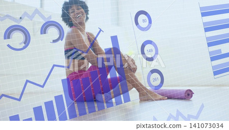 Sitting woman in sports bra, leggings hugging knee at studio, with purple mat and data overlays Sitting woman in sports bra, leggings hugging knee at studio, with purple mat and data overlays 141073034