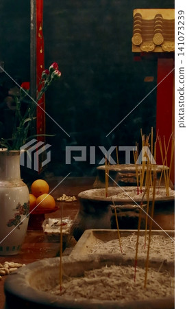 Incense sticks and flowers in a traditional Taoist altar in a calm, spiritual setting during Chinese Lunar New Year in Central, Hong Kong Incense sticks and flowers in a traditional Taoist altar in a calm, spiritual setting during Chinese Lunar New Year in Central, Hong Kong 141073239