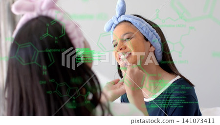 Applying mask, woman wearing navy top tending teen at vanity with plush headbands and green overlay Applying mask, woman wearing navy top tending teen at vanity with plush headbands and green overlay 141073411