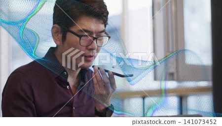 Recording Asian man holding smartphone to mouth at office desk in maroon shirt, waveform overlay Recording Asian man holding smartphone to mouth at office desk in maroon shirt, waveform overlay 141073452