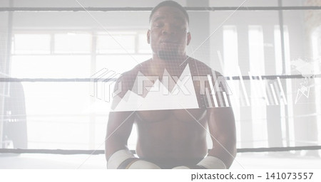 Sitting muscular male boxer catching breath in boxing ring, wearing white gloves and hand wraps Sitting muscular male boxer catching breath in boxing ring, wearing white gloves and hand wraps 141073557