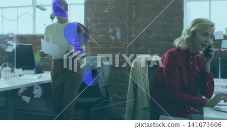 Talking woman in red blouse using smartphone while typing at office, with monitors, copy space Talking woman in red blouse using smartphone while typing at office, with monitors, copy space 141073606