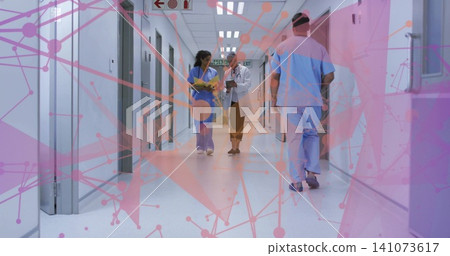 Walking nurse, doctor in scrubs and lab coat, reviewing chart in hospital hall with network overlay Walking nurse, doctor in scrubs and lab coat, reviewing chart in hospital hall with network overlay 141073617