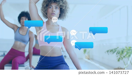 Stretching centered woman lifting arm in studio, wearing pink bra, blue speech-bubble overlays Stretching centered woman lifting arm in studio, wearing pink bra, blue speech-bubble overlays 141073727