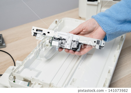 Hand Holding Printer Scanner Carriage During Office Scanner Repair And Maintenance On Desk Hand Holding Printer Scanner Carriage During Office Scanner Repair And Maintenance On Desk 141073982