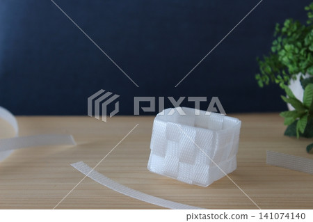 A natural lifestyle image featuring a white woven basket, houseplants, and PP bands. A natural lifestyle image featuring a white woven basket, houseplants, and PP bands. 141074140