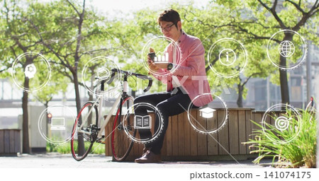 Sitting man wearing pink blazer tapping smartphone on planter at plaza, with bicycle, digital icons Sitting man wearing pink blazer tapping smartphone on planter at plaza, with bicycle, digital icons 141074175