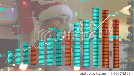 Holding green mug boy wearing Santa hat gazing upward in living room, with financial chart overlay Holding green mug boy wearing Santa hat gazing upward in living room, with financial chart overlay 141074231