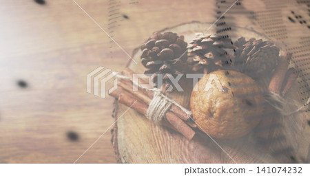 Showing arrangement on wooden table with slice, three cones, tied cinnamon, muffin, printed overlay Showing arrangement on wooden table with slice, three cones, tied cinnamon, muffin, printed overlay 141074232