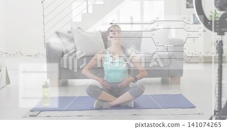 Sitting Korean woman in activewear practicing yoga at home, with mat, ring light, circuit overlay Sitting Korean woman in activewear practicing yoga at home, with mat, ring light, circuit overlay 141074265