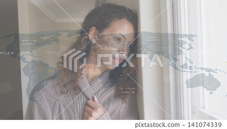 Leaning adult woman holding beige cable-knit sweater collar at home by window, showing map overlay Leaning adult woman holding beige cable-knit sweater collar at home by window, showing map overlay 141074339