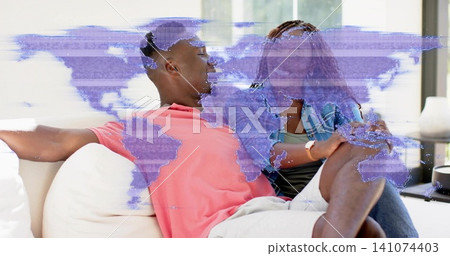 Sitting couple wearing denim jacket and coral shirt on sofa in bright room, purple glitch overlay Sitting couple wearing denim jacket and coral shirt on sofa in bright room, purple glitch overlay 141074403
