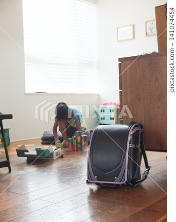 A scene from the living room with black and purple school bags placed on it. A scene from the living room with black and purple school bags placed on it. 141074454