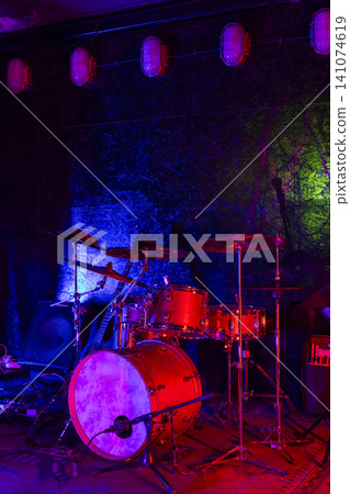 Drum kit on stage with colorful lighting at a concert Drum kit on stage with colorful lighting at a concert 141074619
