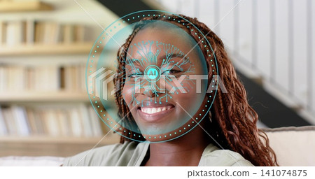 Smiling woman wearing light top sitting on couch in living room, showing teal AI facial overlay Smiling woman wearing light top sitting on couch in living room, showing teal AI facial overlay 141074875